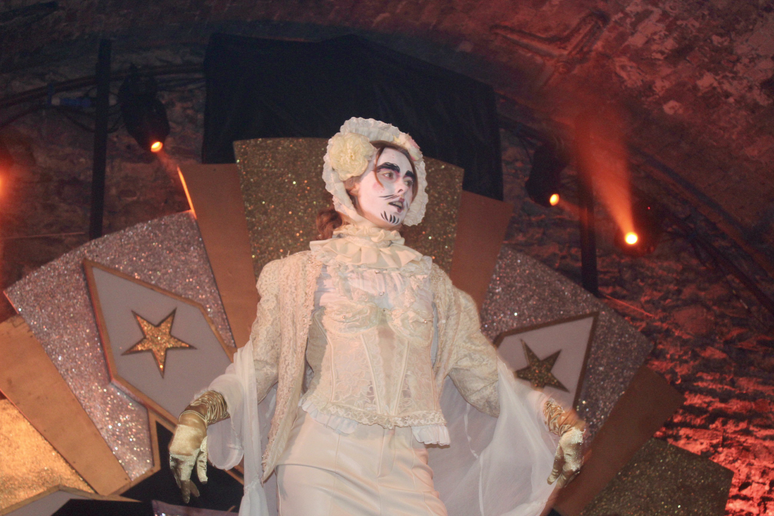 A photograph of Dionysos on stage in his cream ensemble.