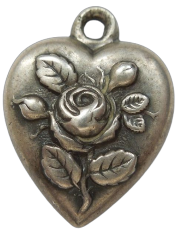a small metal heart with a rose engraved on it.
