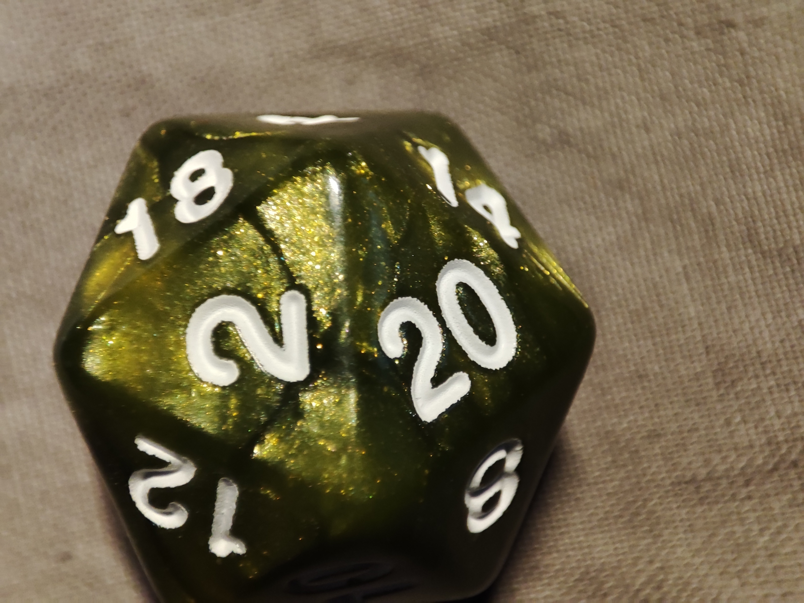 a green glittery twenty-sided die