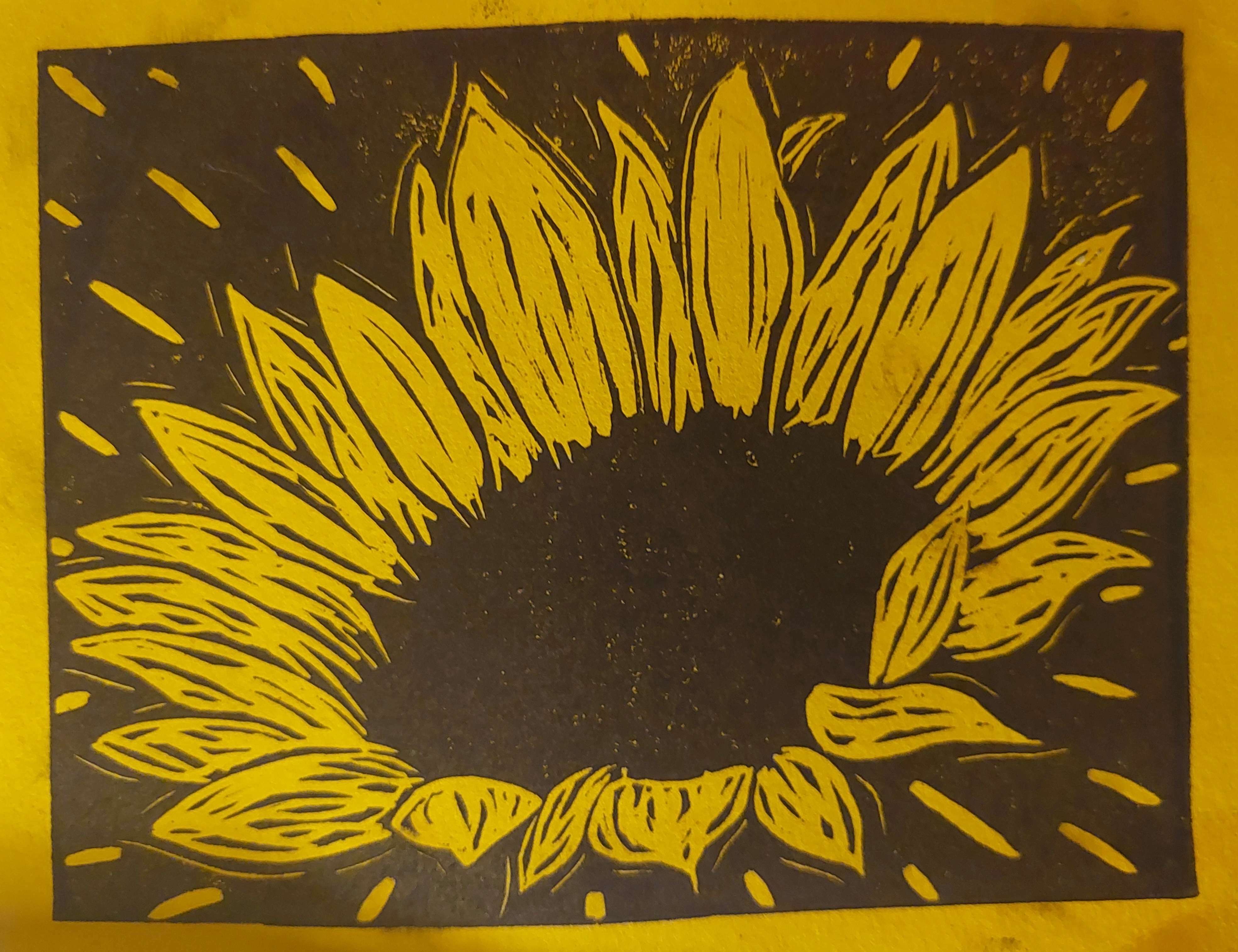 a linoblock print of a sunflower blooming. it is printed in black on yellow paper.