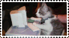A stamp of a cat typing at a computer monitor